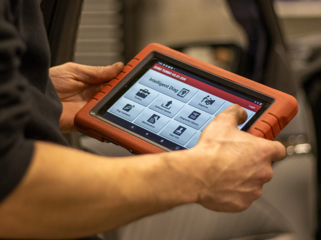 Autonasentaja lukemassa vikakoodeja vikakoodinlukulaitteella.